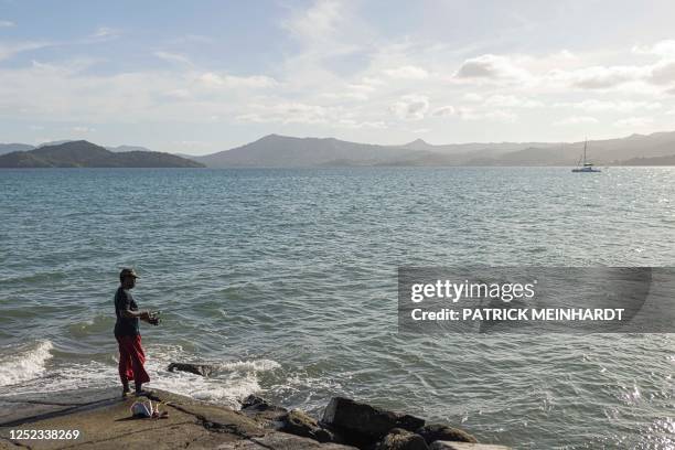 Fisherman uses a fishing rod in Dzaoudzi, on the island of Mayotte, on April 29, 2023.