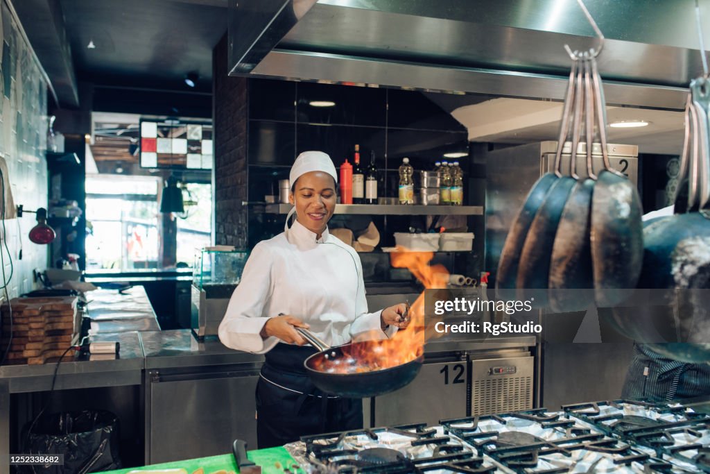 Female chef is preparing a flambé specialty