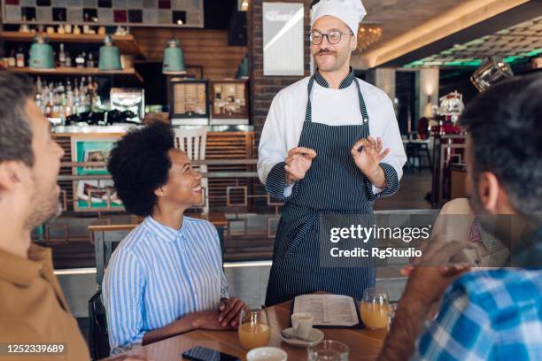 chef recommending some specialties to a group of business people - chef table imagens e fotografias de stock