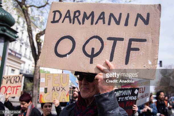 Protesters holding signs and flags during a demonstration against the French Minister of Interior, Gerald Darmanin's legislative proposal on asylum...