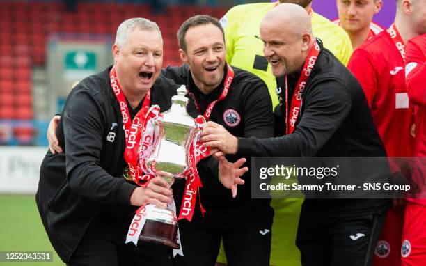 Stirling Albion manager Darren Young celebrates lifting the cinch League Two trophy with his backroom staff after a cinch League Two match between...