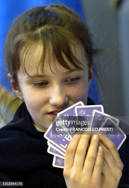 Une fille joue, le 20 février 2004 à Douvrin, à un jeu de cartes "citoyen et républicain", développé par une association luttant contre l'abstention...