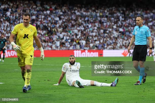 Real Madrid's French forward Karim Benzema on the ground looks on next to Almeria's Spanish goalkeeper Fernando Martinez during the Spanish league...