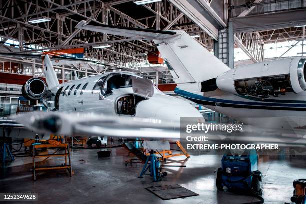 ein kleines privatflugzeug mit einer jet-engine-abdeckung in einem reparaturhangar entfernt - plane engine stock-fotos und bilder