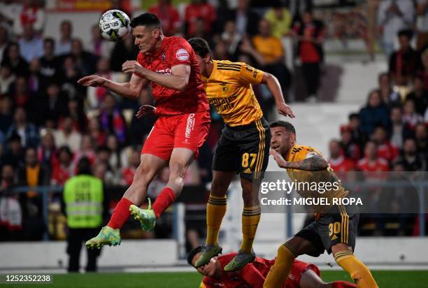 Gil Vicente's Spanish defender Adrian Marin heads th ball next to Benfica's Argentinian defender Nicolas Otamendi and Benfica's Portuguese midfielder...