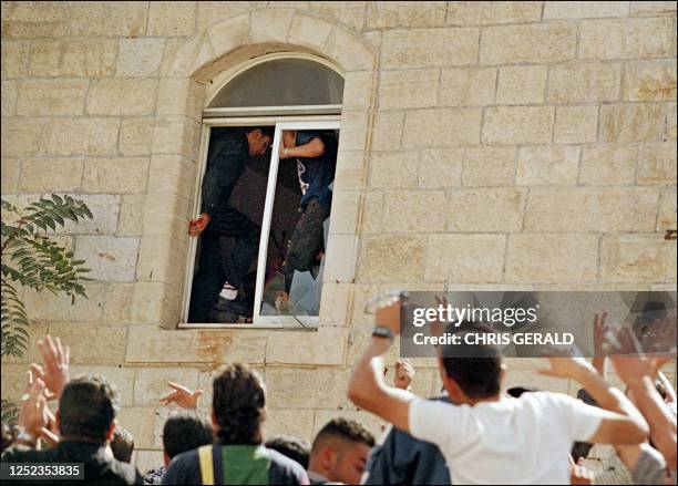 Palestinian youth with Israeli blood on his hands is cheered by fellow protesters at a Palestinian police station in the West bank town of Ramallah...