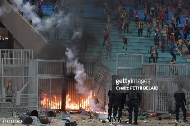 Esperance supporters clash with riot police during the CAF Champions League quarter-final football match between Tunisia's Esperance Sportive de...