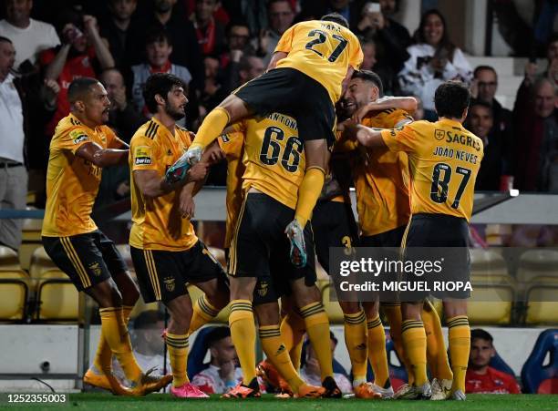 Benfica's Portuguese defender Chiquinho celebrates with teammates after scoring a goal during the Portuguese league football match between Gil...