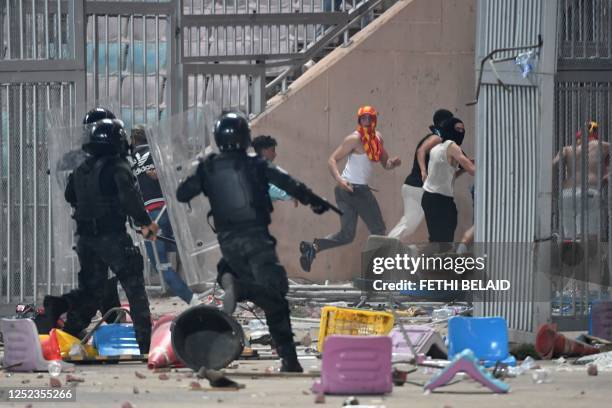 Riot policemen chase Esperance supporters during the CAF Champions League quarter-final football match between Tunisia's Esperance Sportive de Tunis...