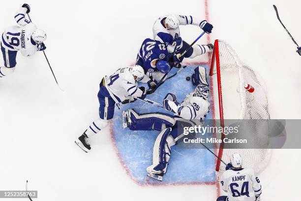 Brayden Point of the Tampa Bay Lightning battles for the puck against Luke Schenn, Morgan Rielly, and goalie Ilya Samsonov of the Toronto Maple Leafs...