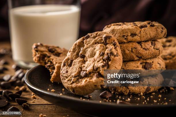 comer galletas de chocolate con un vaso lleno de leche - milk chocolate fotografías e imágenes de stock