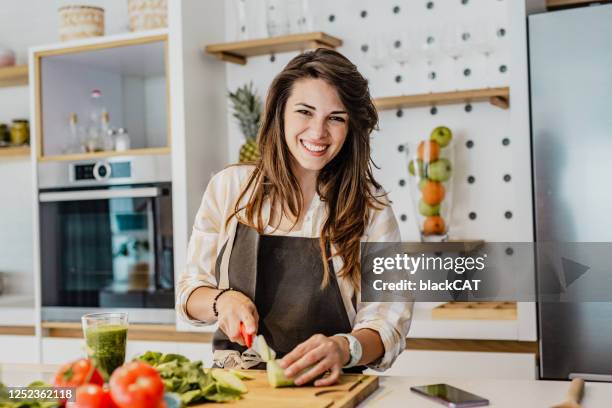 de jonge vrouw bereidt een gezonde drank in keuken voor - kokkin stockfoto's en -beelden