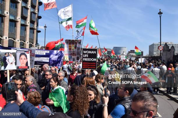 Protesters hold Iranian flags and placards in support of freedom for Iran during the demonstration in Parliament Square. Thousands of protesters...