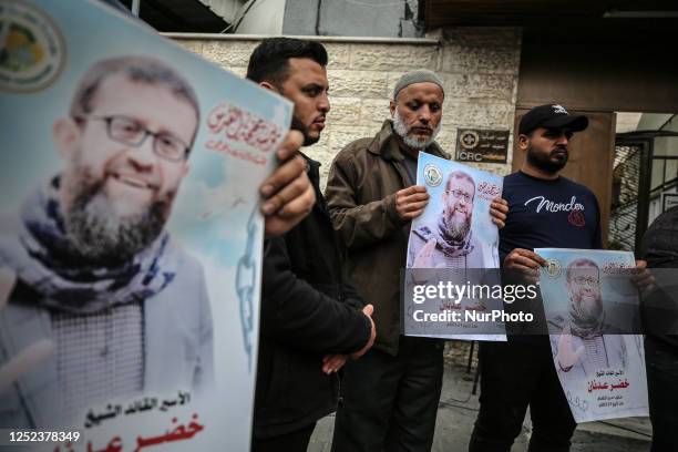 Palestinians hold pictures of Khader Adnan a hunger-striking Palestinian imprisoned in an Israeli jail for 85 days, during a demonstration in...