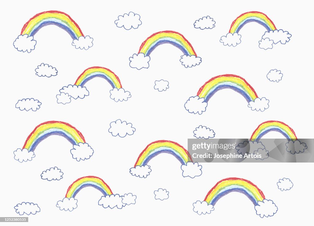 Childs drawing vibrant rainbow and cloud pattern on white background