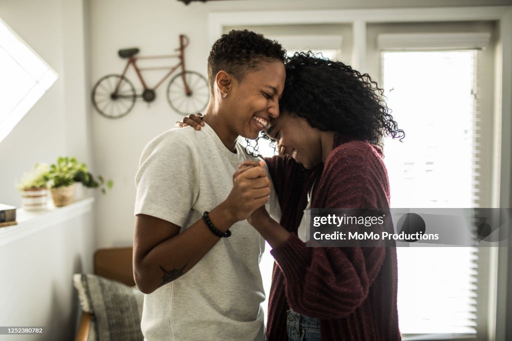 Lesbian couple dancing in living room