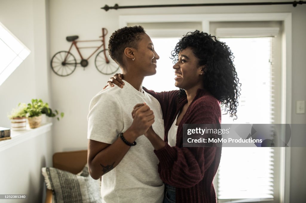 Lesbian couple dancing in living room