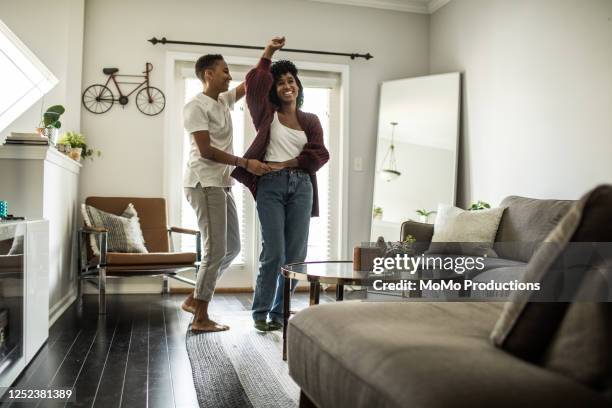 lesbian couple dancing in living room - couple dancing at home stockfoto's en -beelden