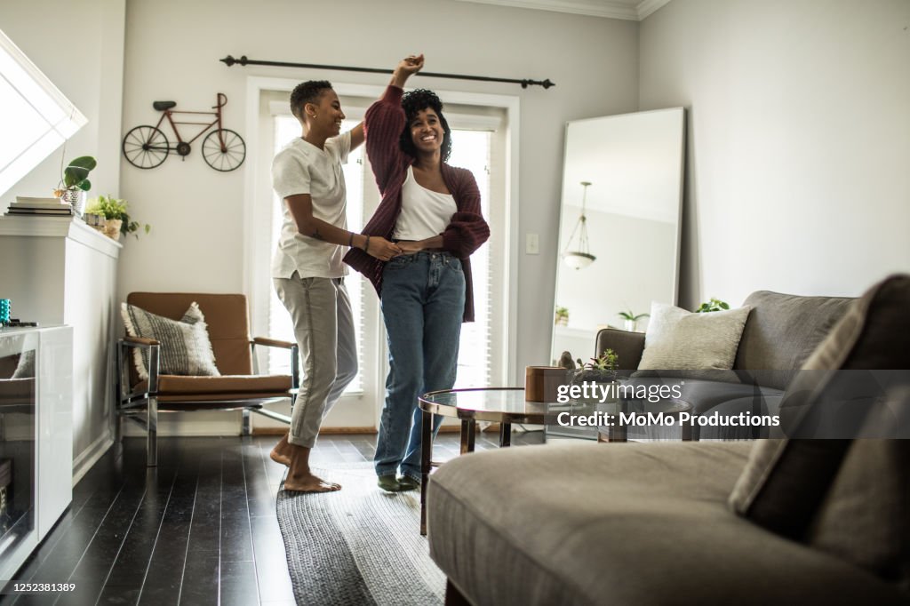 Lesbian couple dancing in living room