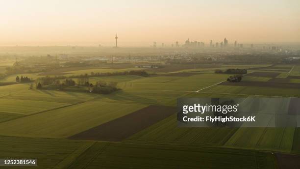 scenic view rural farmland and frankfurt cityscape at sunset, germany - hesse germany stock pictures, royalty-free photos & images