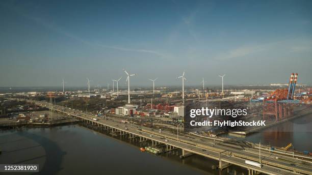 sunny view wind turbines and commercial shipyard, port of hamburg, germany - hamburger hafen stock-fotos und bilder