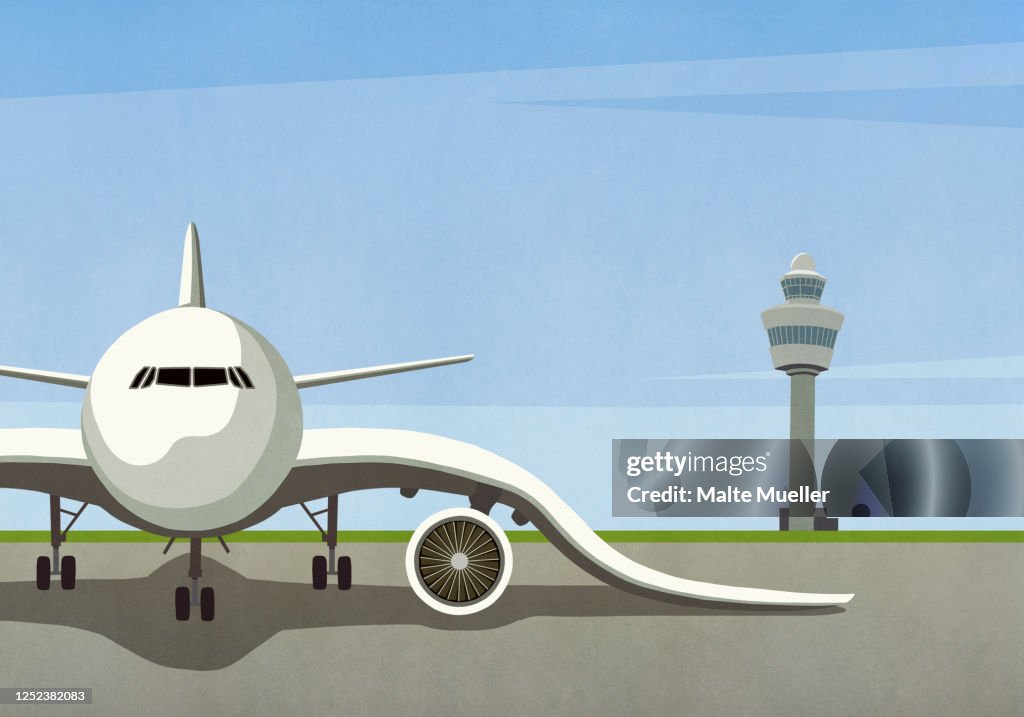 Airplane with drooping wings parked on empty tarmac