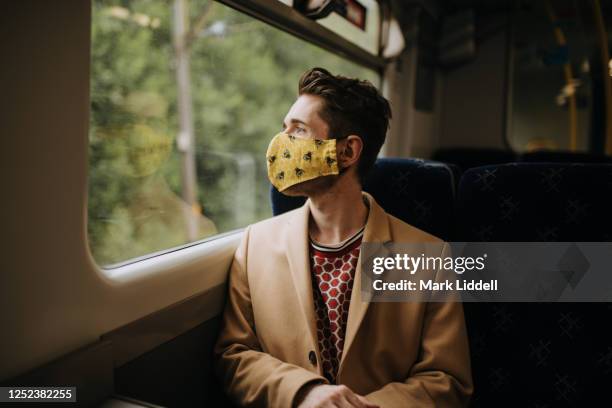 train commuter wearing ppe face mask for safety - covid commuter stock pictures, royalty-free photos & images