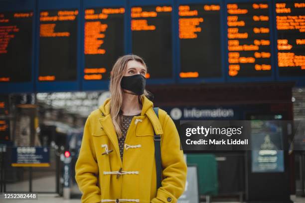 commuter at train station wearing ppe face mask for safety - covid scotland stock pictures, royalty-free photos & images