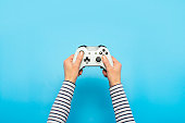 Hands holding a gamepad on a blue background. Banner. Concept games, video games