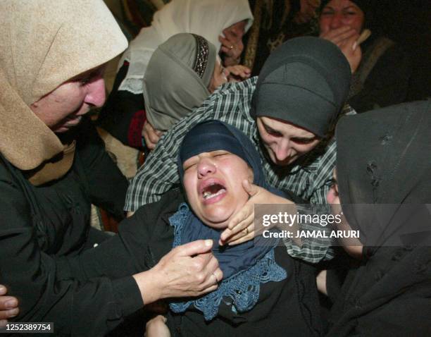 The mother of 10-year-old Palestinian boy Absalam Sumrin collapses during his funeral in el-Bireh, near Ramallah 19 September 2002. The child was...