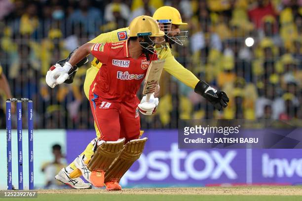 Chennai Super Kings' wicketkeeper Mahendra Singh Dhoni runs to field the ball past Punjab Kings' Prabhsimran Singh during the Indian Premier League...