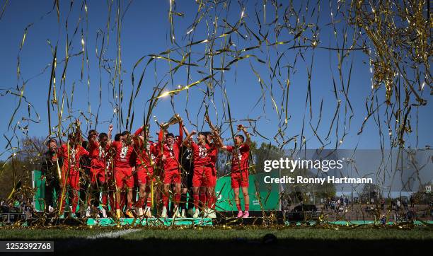 Meiko Waeschenbach of 1. FC Koeln U19 holds the trophy and celebrates winning the DFB Junior Cup Final match with team mates during the DFB Junior...