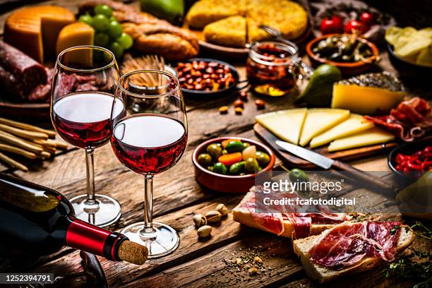 köstliche vorspeise mit rotwein auf rustikalem holztisch - tapas stock-fotos und bilder
