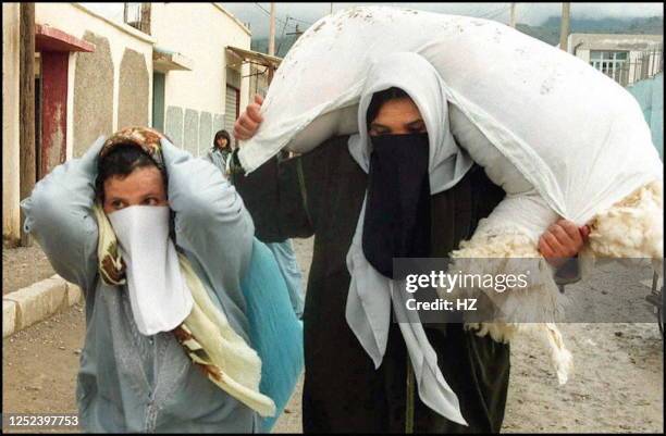 Veiled women flee the village of Benachour 07 December after a bloody massacre, blamed on Islamic fundamentalist militants fighting to overthrow the...