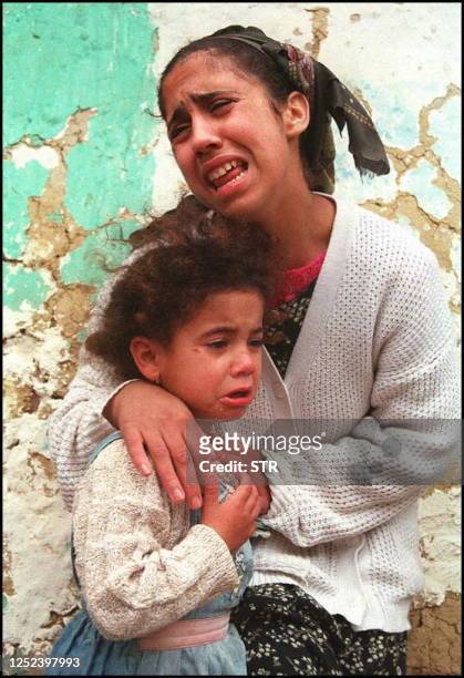 Woman and her child mourn 24 January the victims of the latest known massacre in Algeria which happened Thursday night in the Baba Ali region just...