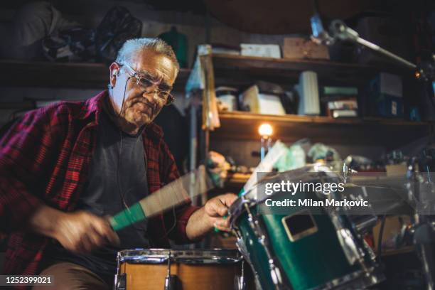 an older man practices playing bunje - remembering the younger days - happy older man - playing drums stock pictures, royalty-free photos & images