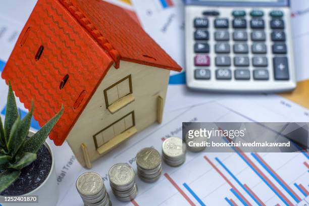 house resting on calculator concept for mortgage calculator, home finances or saving for a house - housing loan stockfoto's en -beelden