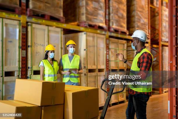 warehouse worker wearing protective mask to protect against covid-19 - medical footwear stock pictures, royalty-free photos & images