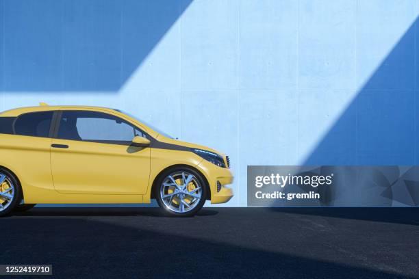 generic modern car against concrete wall - yellow car stock pictures, royalty-free photos & images