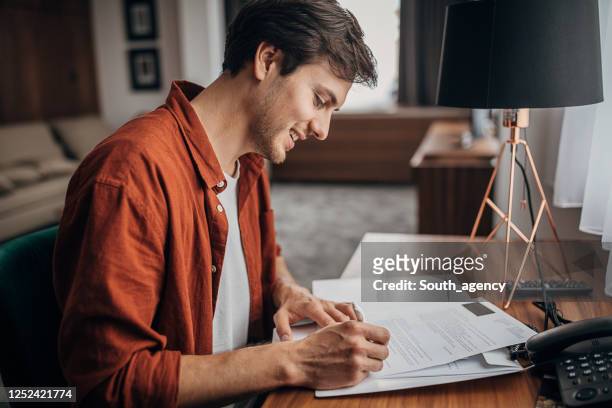 young man in hotel room - reading contract stock pictures, royalty-free photos & images