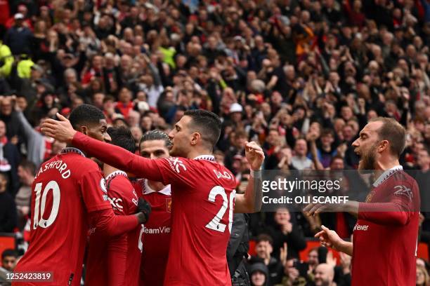 Manchester United's Portuguese midfielder Bruno Fernandes celebrates with teammates after scoring his team first goal during the English Premier...
