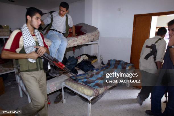 Palestinian security members leave their bedroom inside a building of the Muqataa, Palestinian leader Yasser Arafat's headquarters, after Israeli...