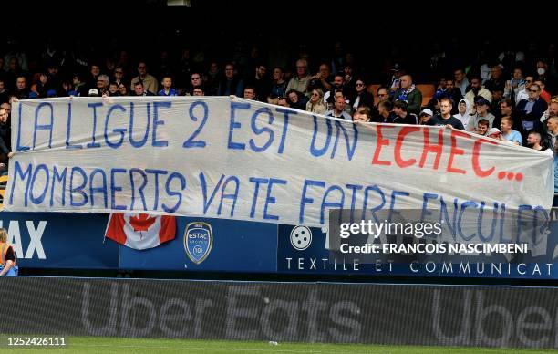Graphic content / Troyes' fans hold a banner reading "League 2 is a failure, Mombaerts go get fucked" during the French L1 football match between ES...