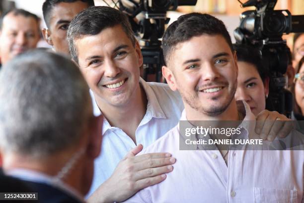 Paraguayan presidential candidate for the Colorado party, Santiago Peña , gestures next to his son before casting his vote at the Santa Ana school in...