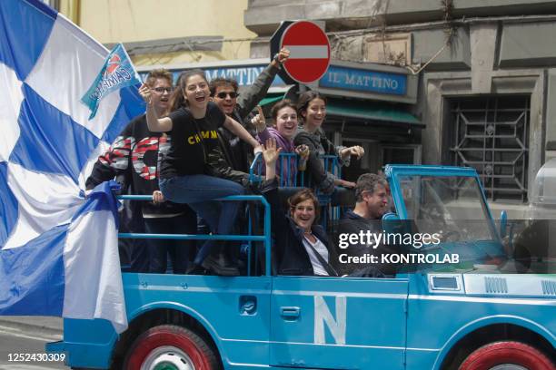 Group of fans of the SSC Napoli soccer team shout slogans from an open vehicle decorated with the colors of the team and the effigy of the "Scudetto"...