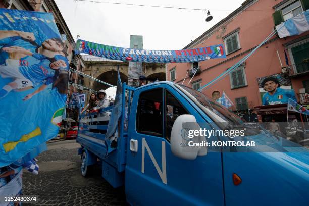 Group of fans of the SSC Napoli soccer team shout slogans from an open vehicle decorated with the colors of the team and the effigy of the "Scudetto"...