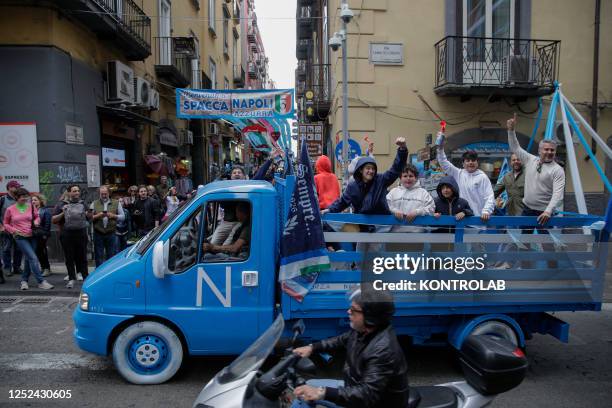 Group of fans of the SSC Napoli soccer team shout slogans from an open vehicle decorated with the colors of the team and the effigy of the "Scudetto"...