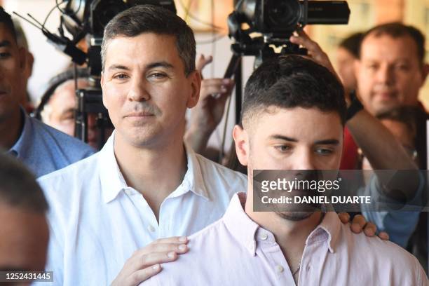 Paraguayan presidential candidate for the Colorado party, Santiago Peña , gestures next to his son before casting his vote at the Santa Ana school in...