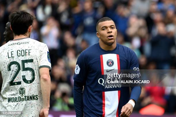 Paris Saint-Germain's French forward Kylian Mbappe reacts next to Lorient's French defender Vincent Le Goff during the French L1 football match...