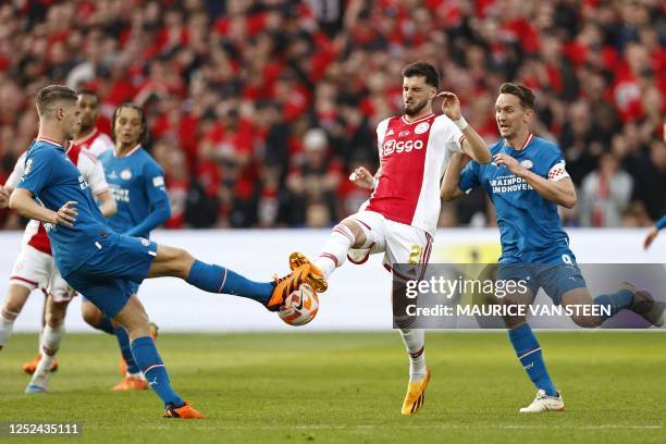 S Dutch midfielder Joey Veerman fights for the ball with Ajax's Austrian midfielder Florian Grillitsch and PSV's Dutch forward Luuk de Jong during...